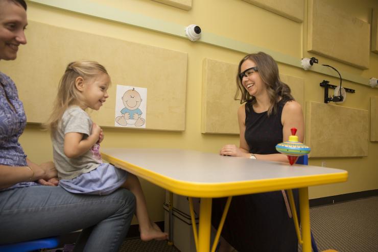 A therapist measuring eye contact while a child plays during therapy sessions.