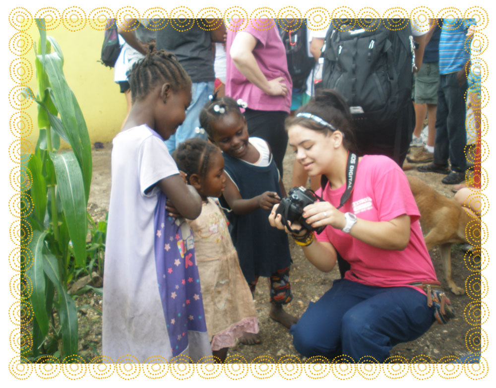 A Georgia Tech student shows pictures on her camera to a local child