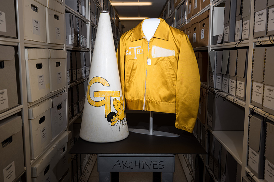 This men’s satin cheerleader jacket, worn by student John Walter Lay Jr. in 1948, is pictured with a cheerleader megaphone.