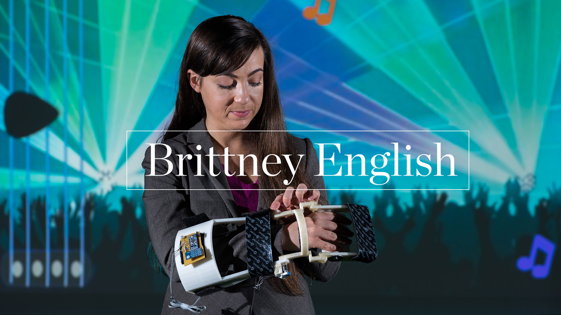 photo -  Brittney English and controler for video game projected on screen behind her.