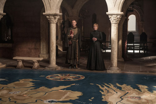 A scene from HBO's Game of Thrones showing Circe Lanister smiling vindictively over a map of the world.