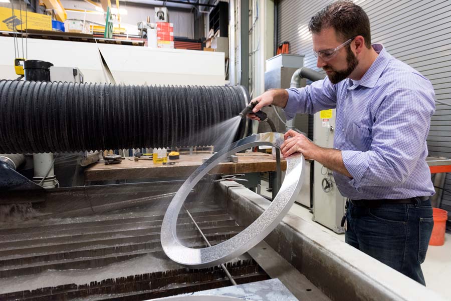 Water jetting simultaneously provides speed and quality, which helps contain project costs. cole Burton, shop engineer, cleans a metal ring that is part of a focus beam measuring system built by GTRI.