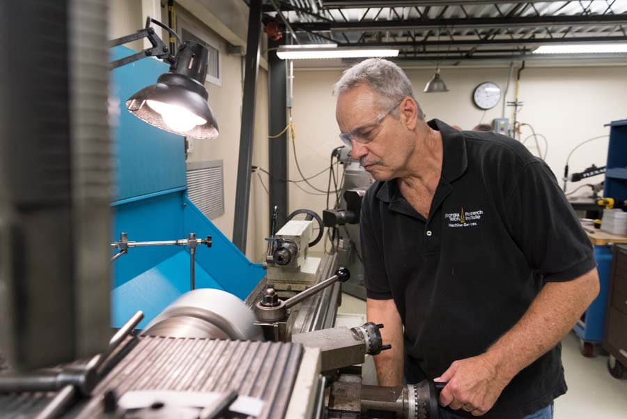 Jim Tober, instrument maker, uses an engine lathe to turn a customized device for a Georgia Tech customer.