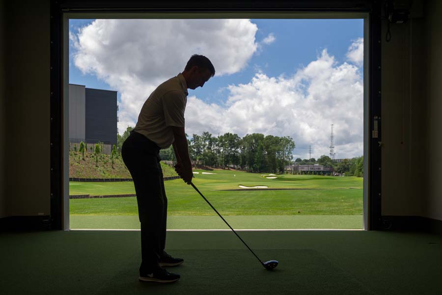 Assistant Golf Coach Drew McGee in a hitting bay at the Matt Kuchar Teaching Center.