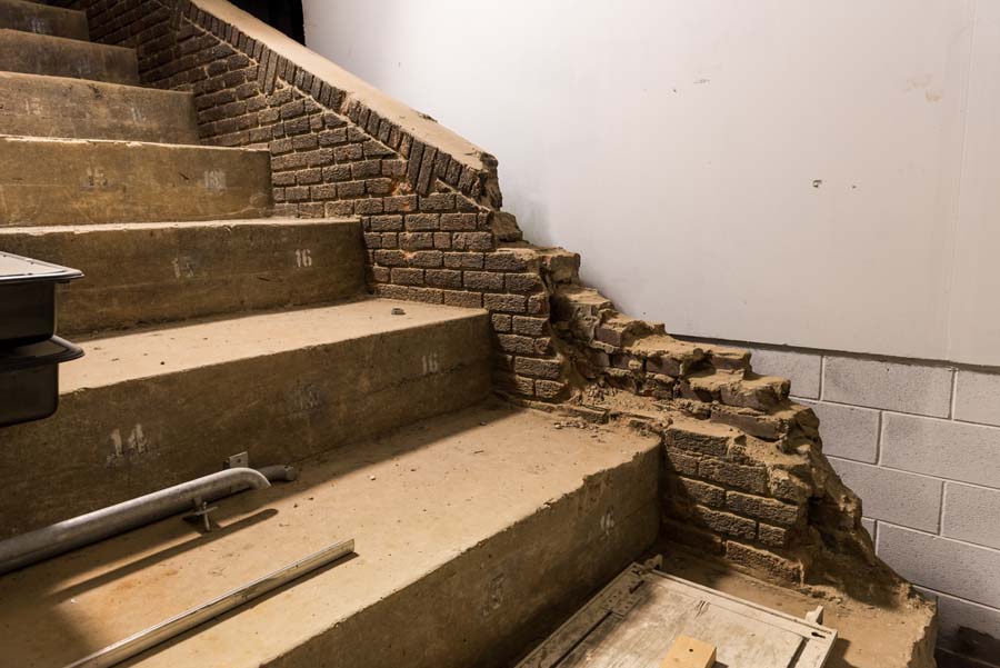 The renovated West Stands are larger than the original stands, which ended at the brick wall.