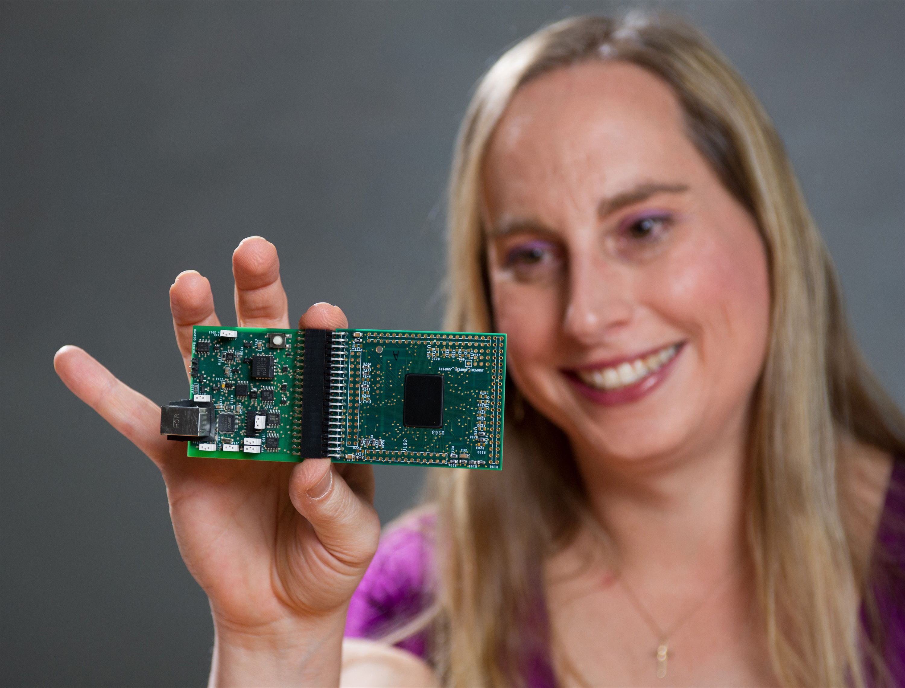Professor Jennifer Hasler displays a field programmable analog array (FPAA) board that includes an integrated circuit with biological-based neuron structures for power-efficient calculation. Hasler’s research indicates that this type of board, which is programmable but has low power requirements, could play an important role in advancing neuromorphic computing. (Georgia Tech Photo: Rob Felt) Professor Jennifer Hasler displays a field programmable analog array (FPAA) board that includes an integrated circuit with biological-based neuron structures for power-efficient calculation. Hasler’s research indicates that this type of board, which is programmable but has low power requirements, could play an important role in advancing neuromorphic computing. (Georgia Tech Photo: Rob Felt)