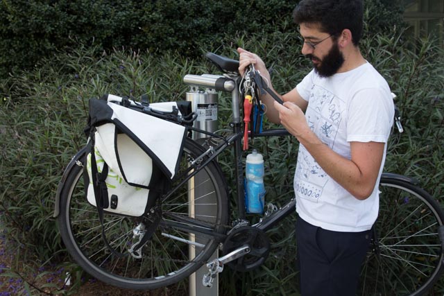 Physics grad student Michael Tennenbaum, Bicycle Infrastructure Improvement Committee co-chair and president of Starter Bikes, demonstrates how to use the fix-it station at the Campus Recreation Center.