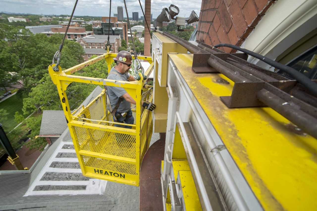 A construction worker replaces the letters on Tech Tower.