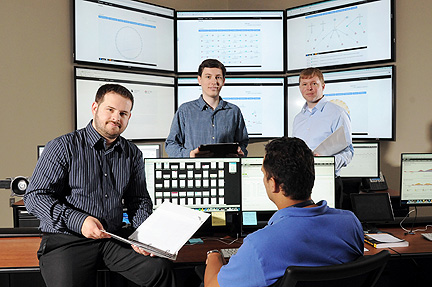 Georgia Tech Research Institute (GTRI) cyber-security specialists Christopher Smoak, Bryan Massey and Ryan Spanier (l-r) pose in facilities used to gather information on the activities of hackers and pending cyber attacks. GTRI has developed a new open source intelligence gathering system known as BlackForest. (Georgia Tech Photo: Gary Meek)