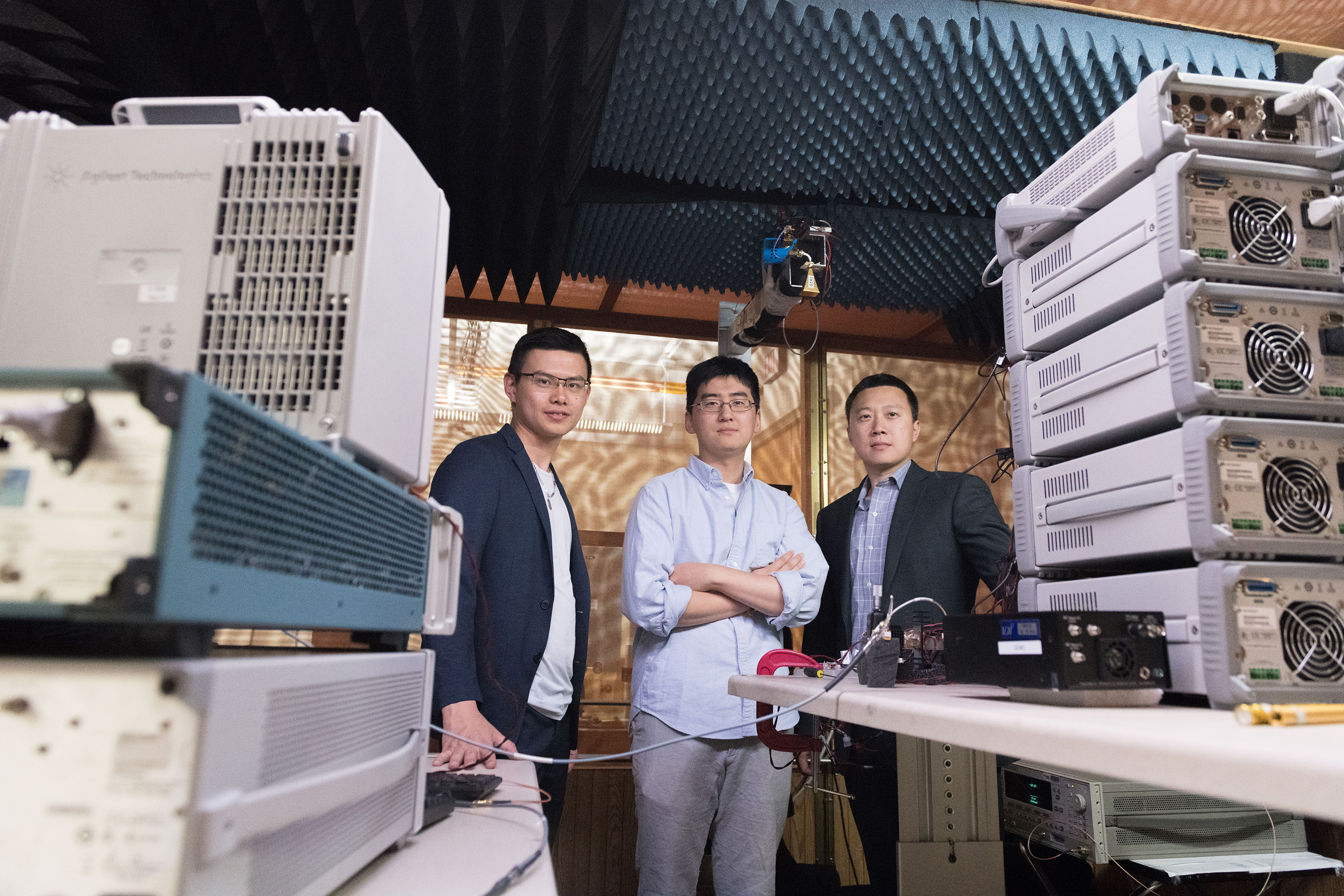 Georgia Tech researchers are shown with electronics equipment and antenna setup used to measure far-field radiated output signal from millimeter wave transmitters. Shown are Graduate Research Assistant Huy Thong Nguyen, Graduate Research Assistant Sensen Li, and Assistant Professor Hua Wang. (Credit: Allison Carter, Georgia Tech)