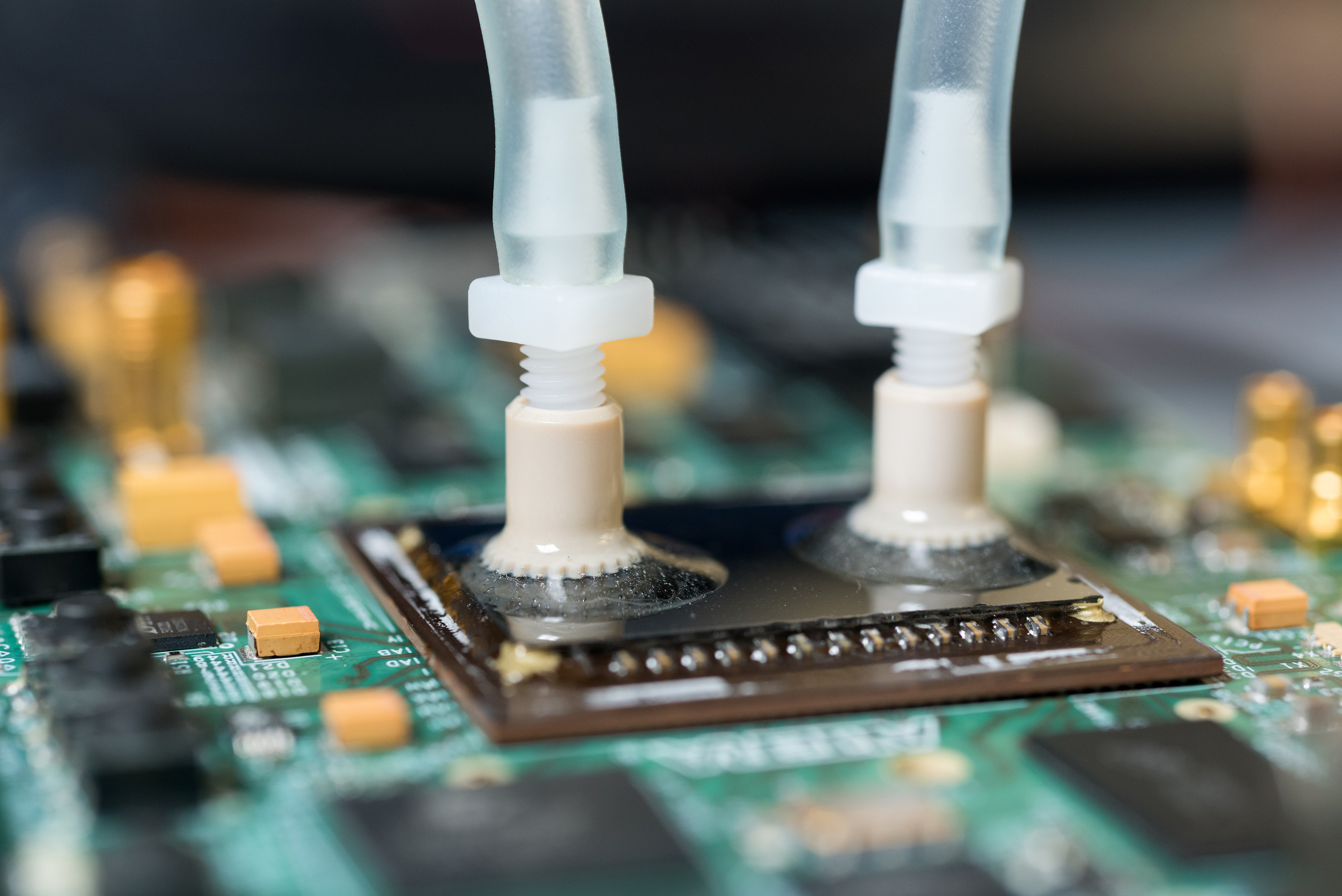 Liquid ports carry cooling water to specially designed passages etched into the backs of FPGA devices to provide more effective cooling. The liquid cooling provides a significant advantage in computing throughput. (Credit: Rob Felt, Georgia Tech) Liquid ports carry cooling water to specially designed passages etched into the backs of FPGA devices to provide more effective cooling. The liquid cooling provides a significant advantage in computing throughput. (Credit: Rob Felt, Georgia Tech)