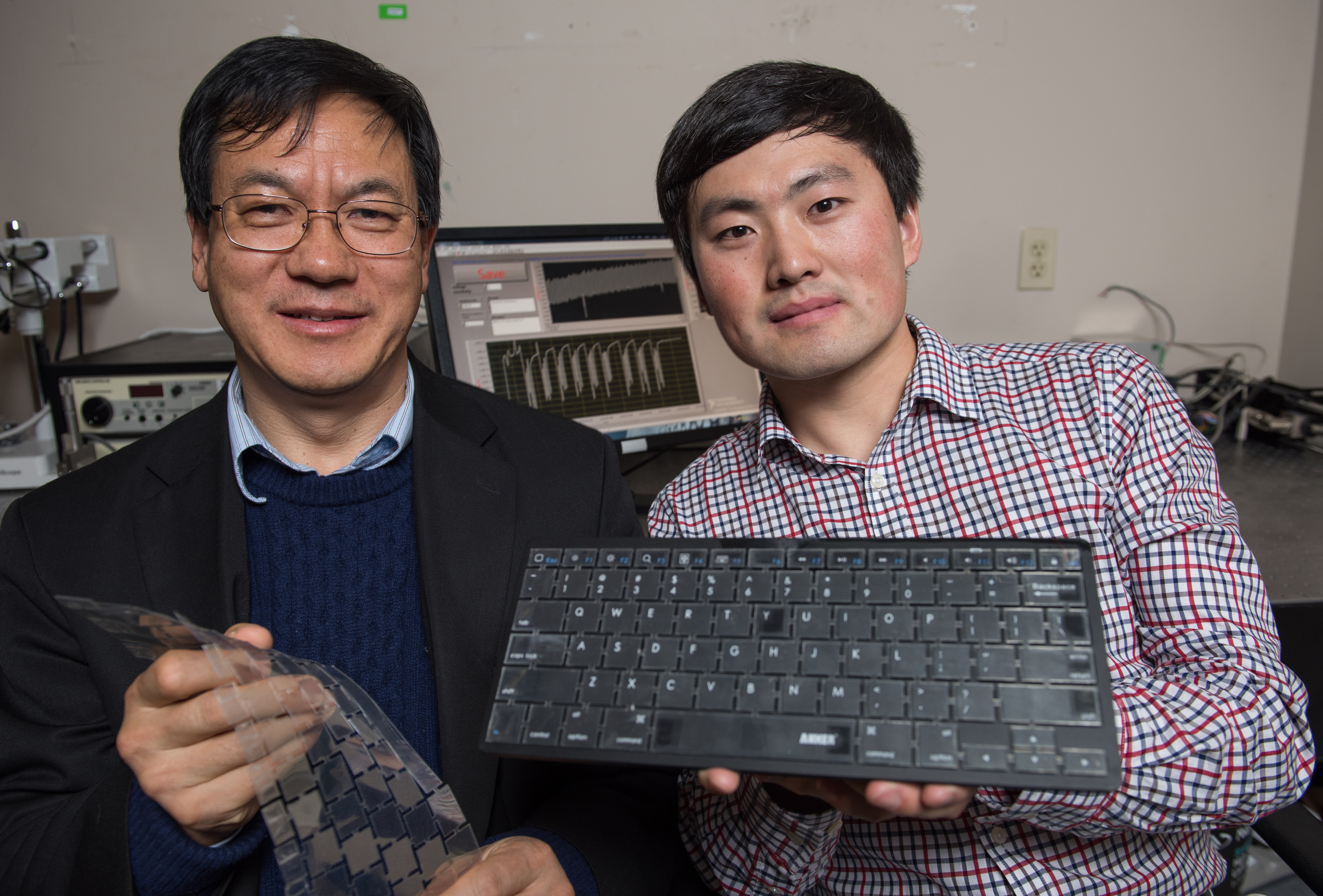 Georgia Tech Professor Zhong Lin Wang (left) and graduate research assistant Jun Chen display their new self-powered keyboard. The device could provide a stronger layer of security for computer users. (Credit: Rob Felt)