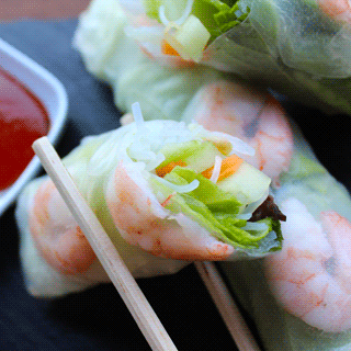 A Vietnamese spring roll being held in chopsticks.