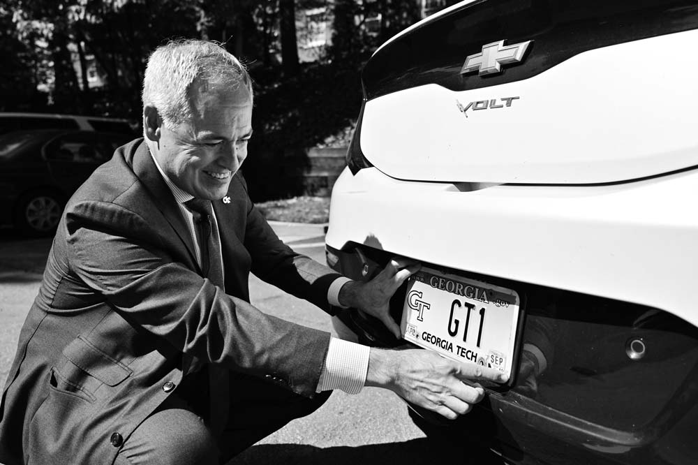 President Cabrera putting on his GT1 license plate on his Chevy Volt