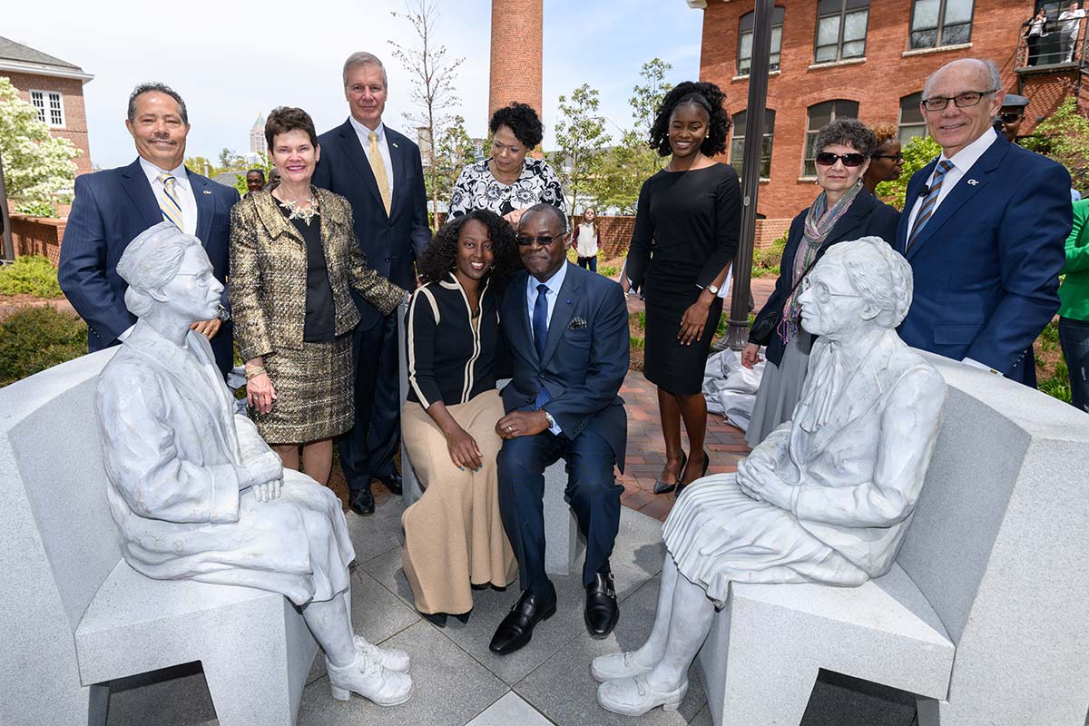 Group photo of people with the Continuing the Conversation sculpture