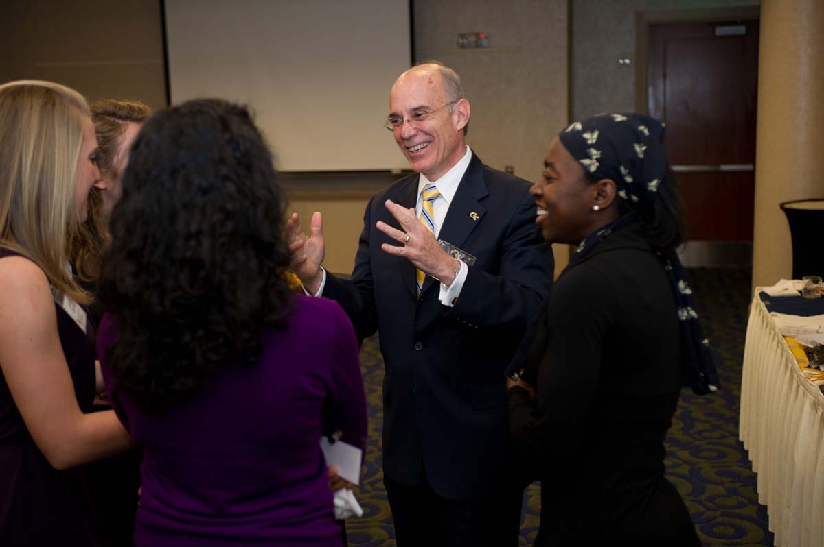 Provost Bras and students standing in a circle talking