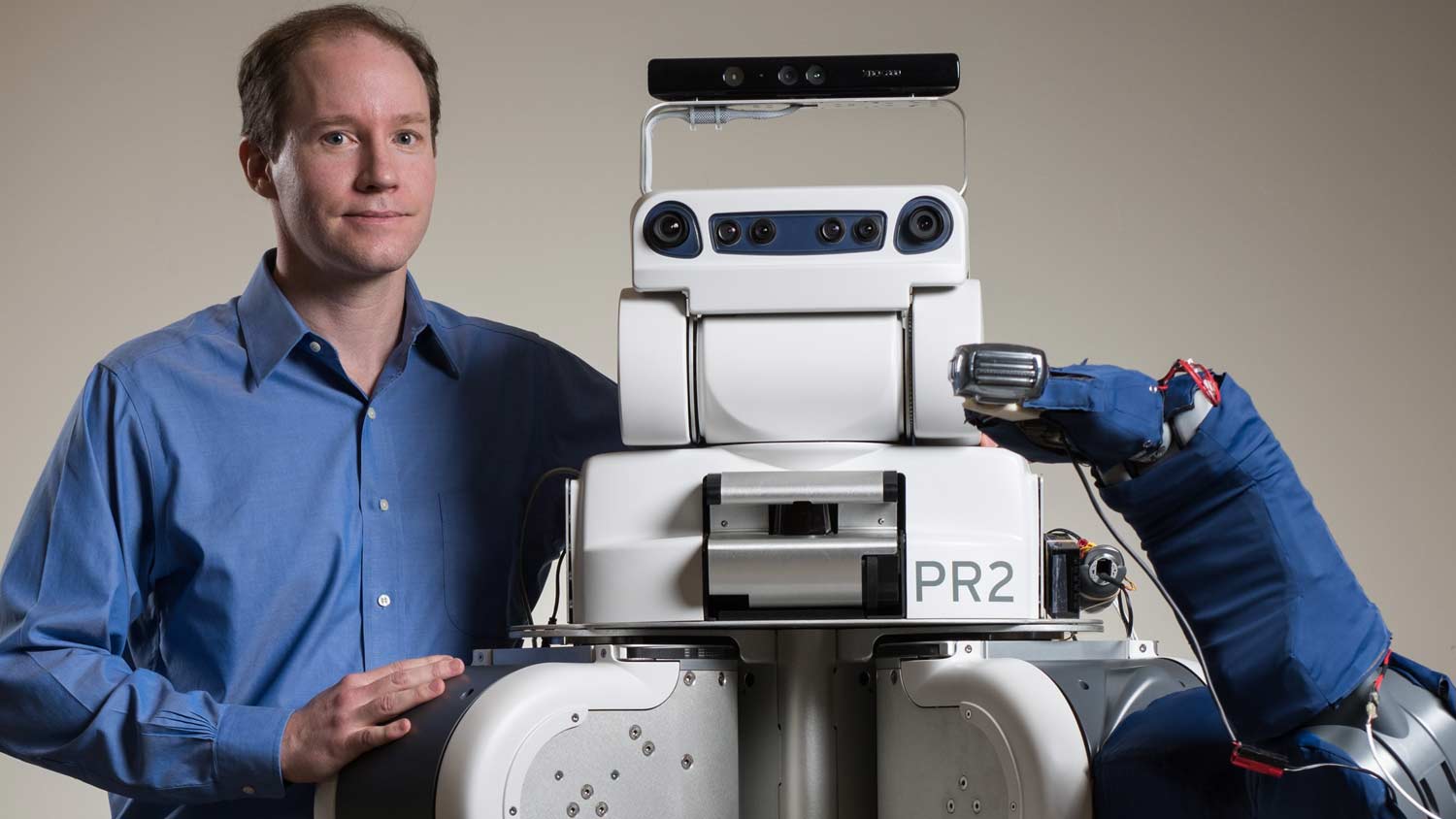 charlie kemp poses with assistive robot, pr2