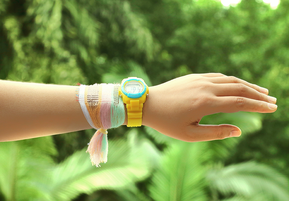 A person's hand with fabric tied around it. The fabric can absorb both solar power and motion for energy.