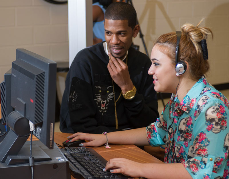 Young Guru helping a student compose code and music with EarSketch
