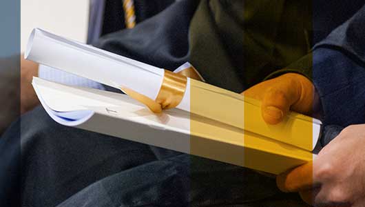 photo - graduate holding diploma and program