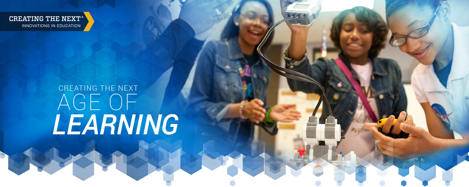 Several students at Coretta Scott King Young Women's Leadership Academy smiling and working with robots