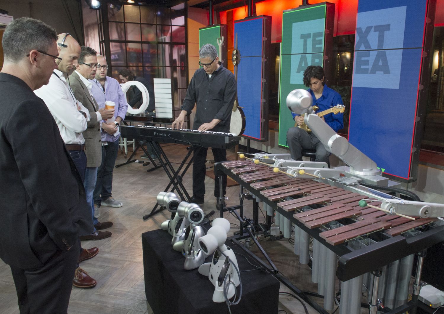 NBC members watch as Gil Weinberg and Mason Bretan practice a few hours before the live segment.