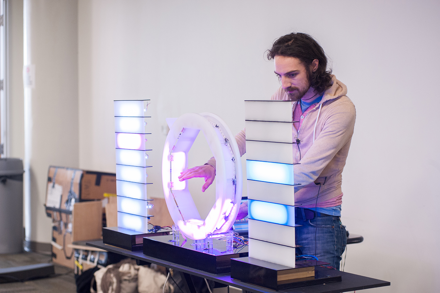 Man with hand inside circle that is part of an instrument with two small towers