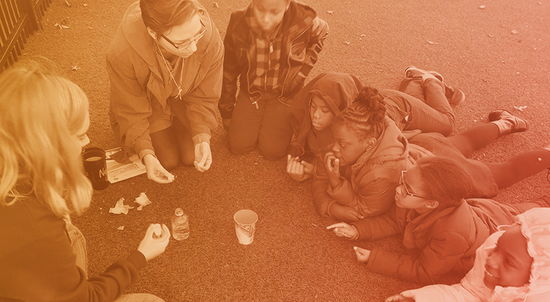 Stempower volunteers teaching several elementary school kids in a hands-on setting