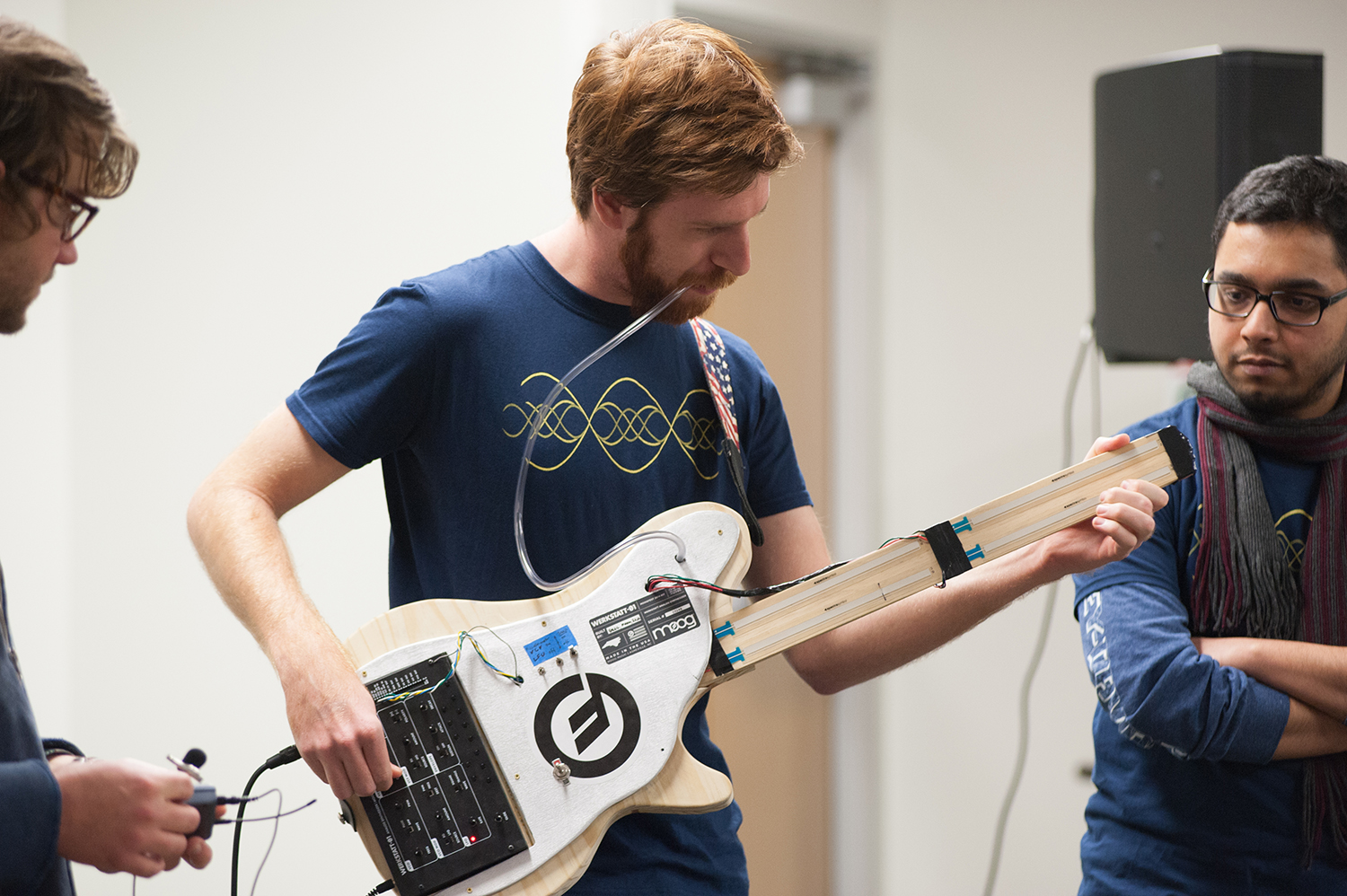 Man playing guitar with tube attached that is in his mouth