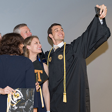 student takes a selfie at graduation