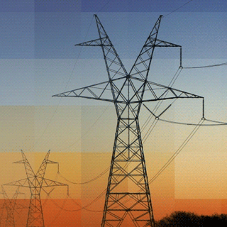 Two electricity power poles silouetted against the sky.