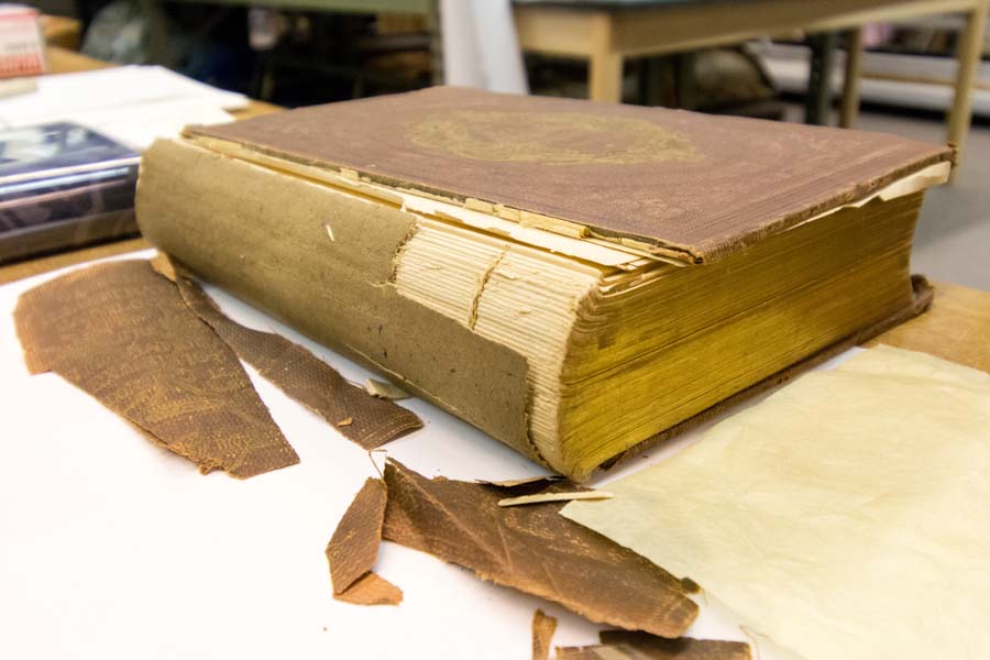 Some of the museum’s older books, such as this one from 1862, are in need of repair. A volunteer book conservator helps make repairs.