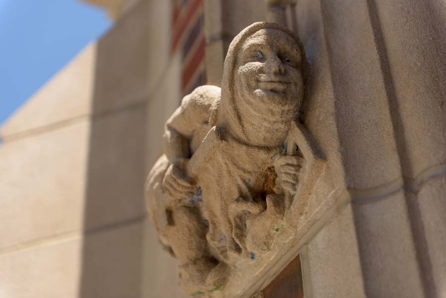 Gargoyle-like figures holding tools flank the entrance to Harris Hall.