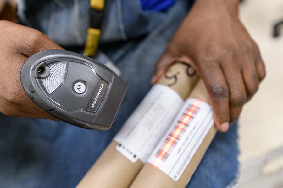 Employees scan barcodes on trackable packages.