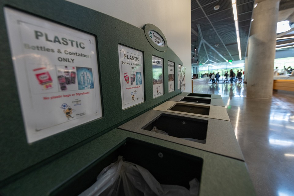 Indoor recycling bins, like this one in Clough Commons, include square containers for plastic, landfill, aluminum, and paper. This has been the campus standard since 2006.