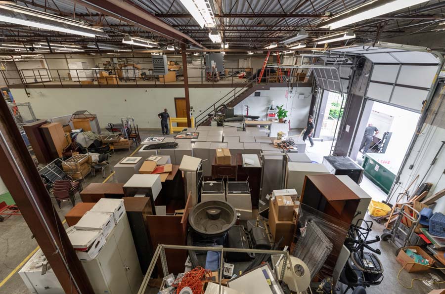 The 5,730-square-foot space has a little bit of everything, from electronics to furniture. Unloading and staging the items are Tias Climes, truck driver; Christopher Wallace, logistics associate; and Corey Darden, logistics associate.