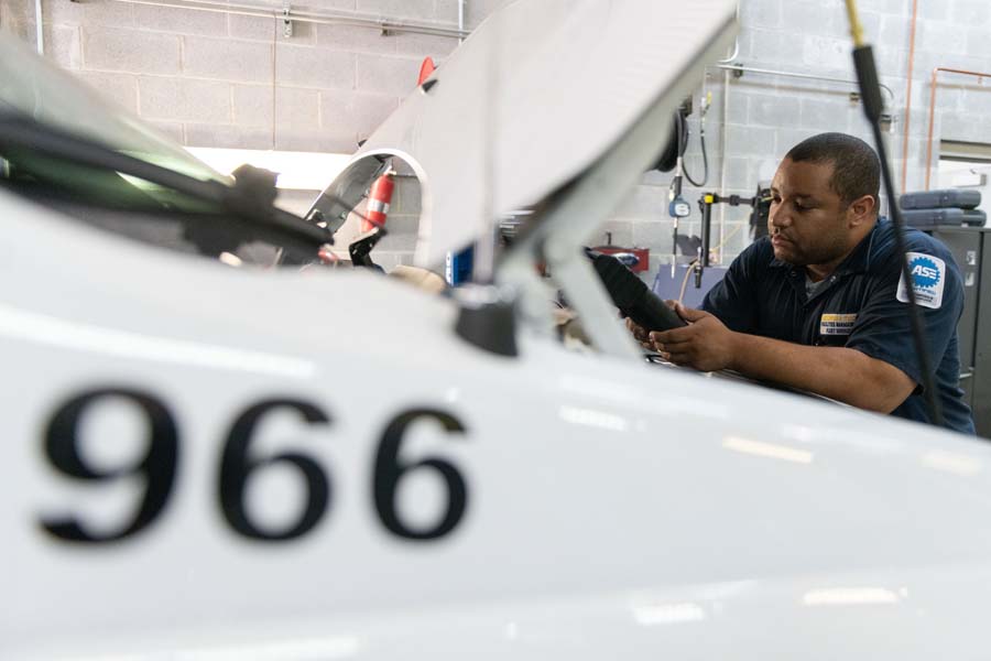 Alan Henry, Automotive Service Excellence (ASE)-certified automotive mechanic, checks the battery voltage as part of preventive maintenance.