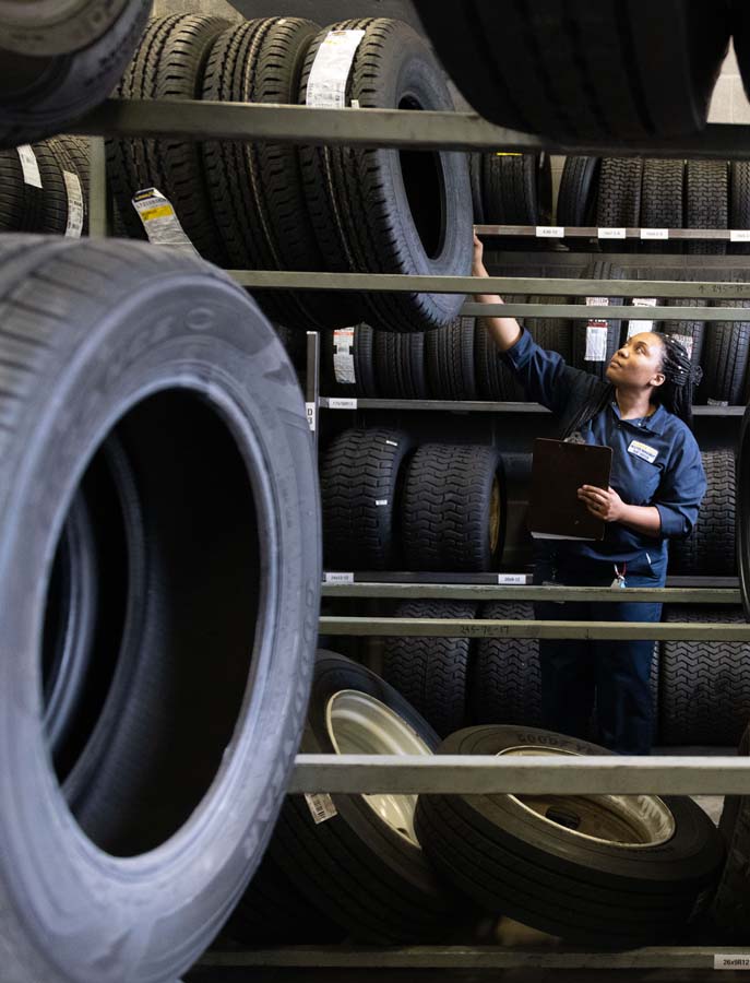 Natasha Carter, ASE-certified automotive parts specialist, checks inventory in the parts room.