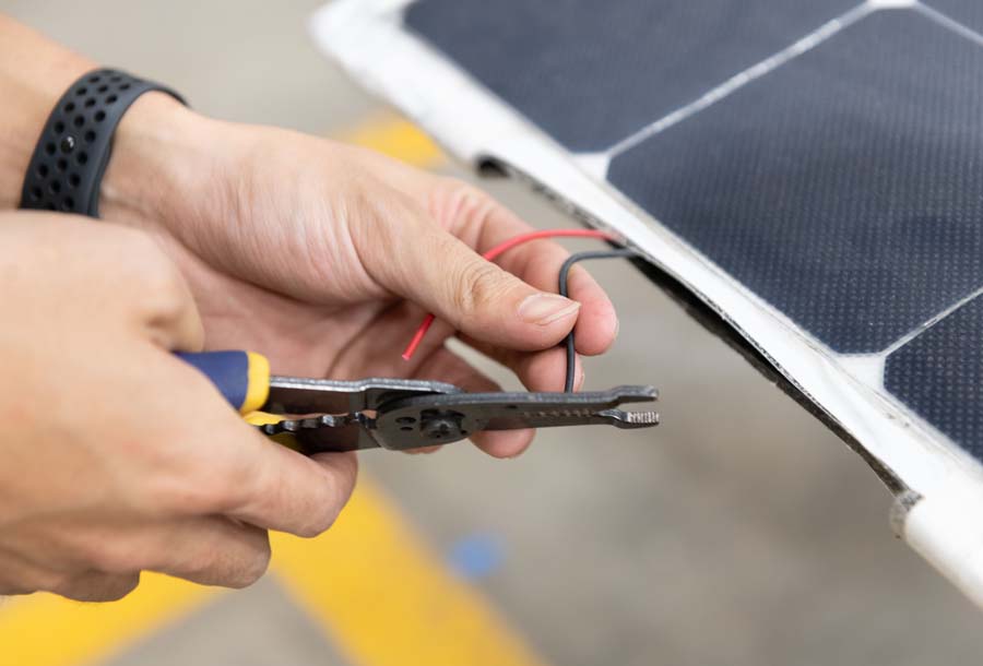 A GT Solar Racing student adjusts the connection on the solar-powered racecar.