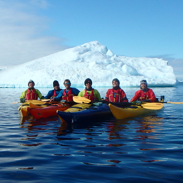 Six Georgia Tech kayakers in front of an iceberg in Antarctica.