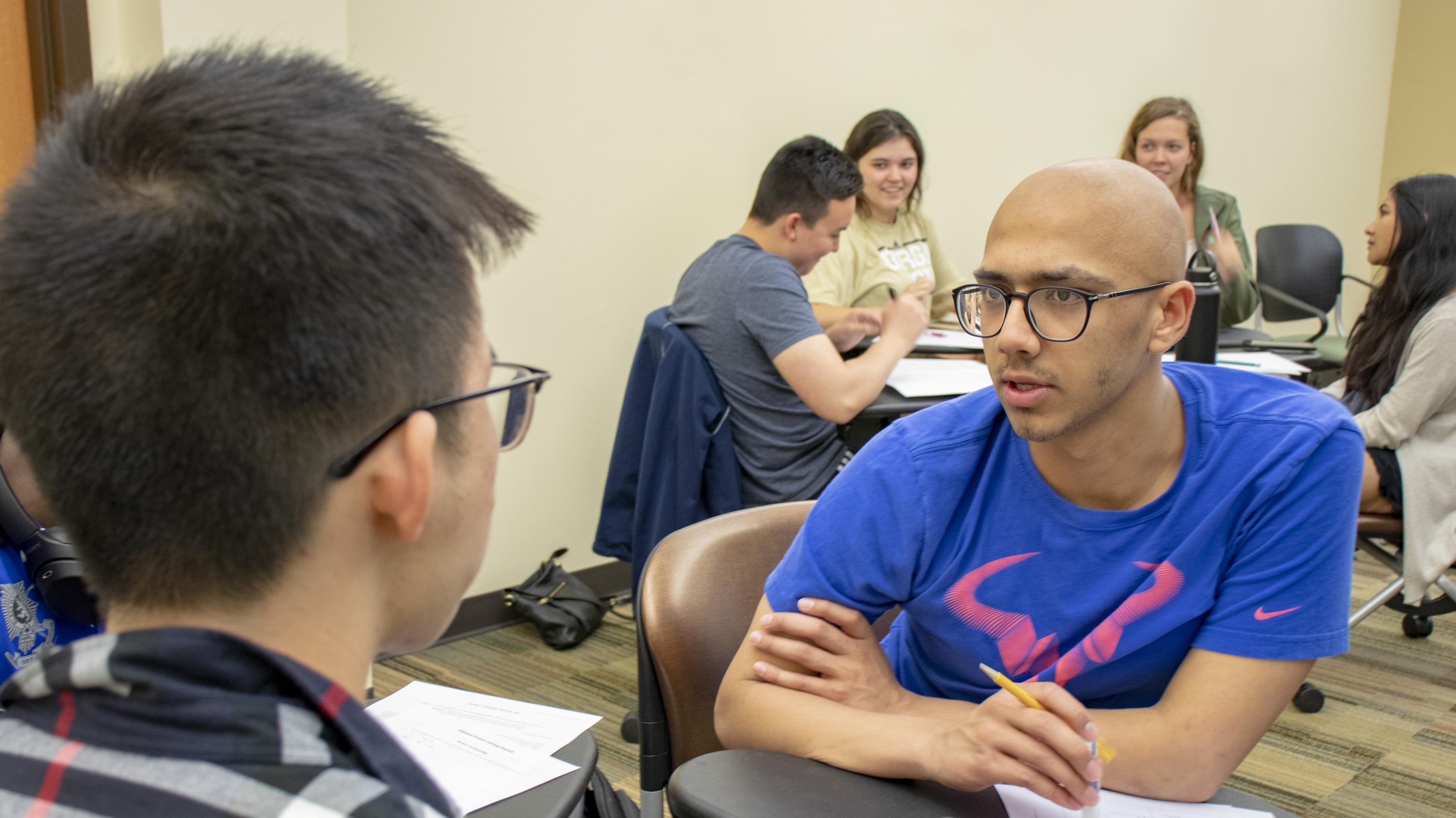 Student Jeremy Hua, left, brainstorms with Shovan Bhatia about their goals for the next 10 years during the April 17, 2019 session of Career Design for Global Citizenship. In the background, students Ian Bunker, Jaynie Rice, Caitlyn Beals, and Sabirah Haque discuss their final project, in which students design several alternative life paths.