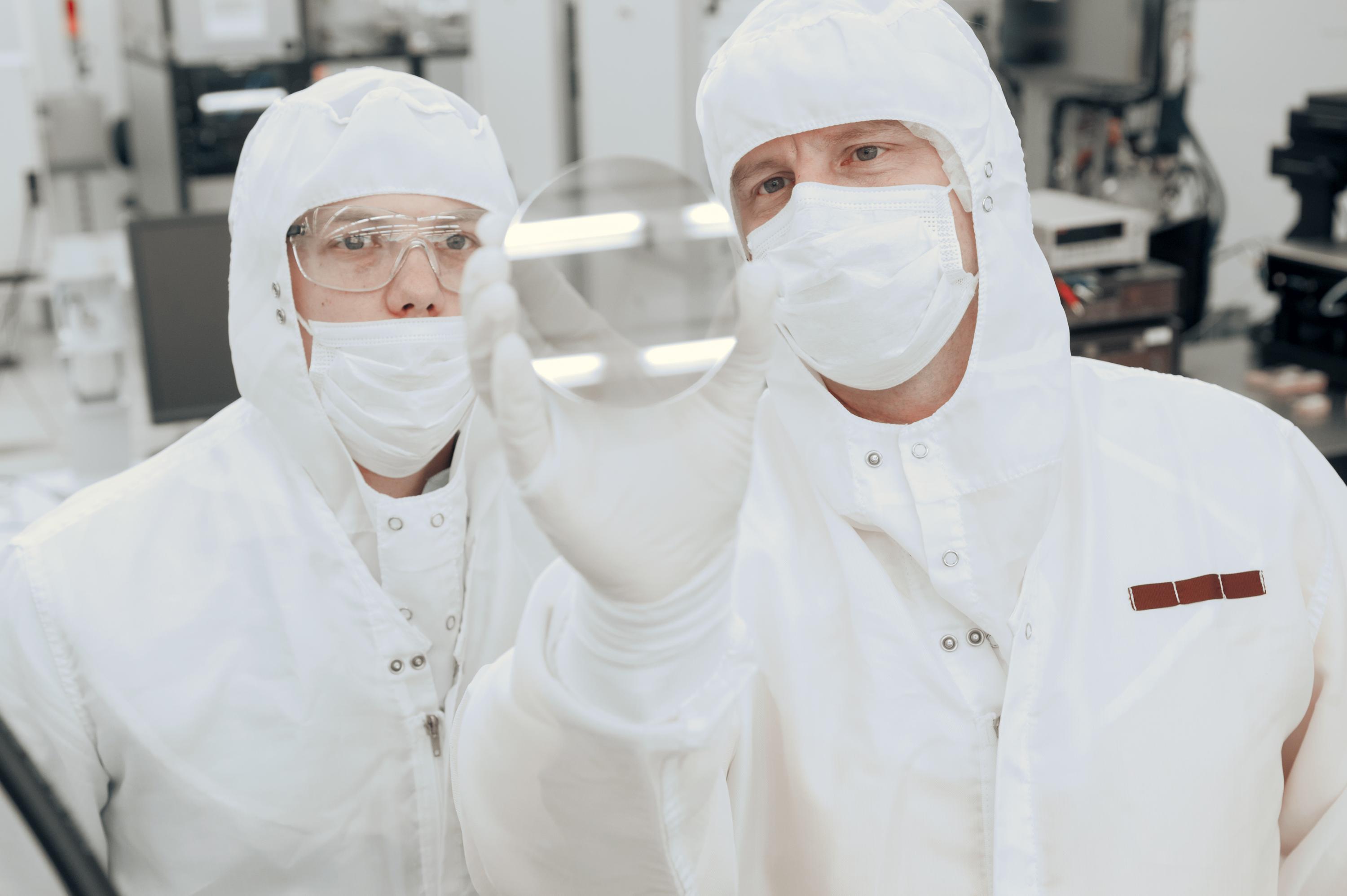 Georgia Tech professor Alan Doolittle and research engineer Brooks Tellekamp hold up an example of nanoscale materials used in advanced computing. Credit: Georgia Tech / Christopher Moore