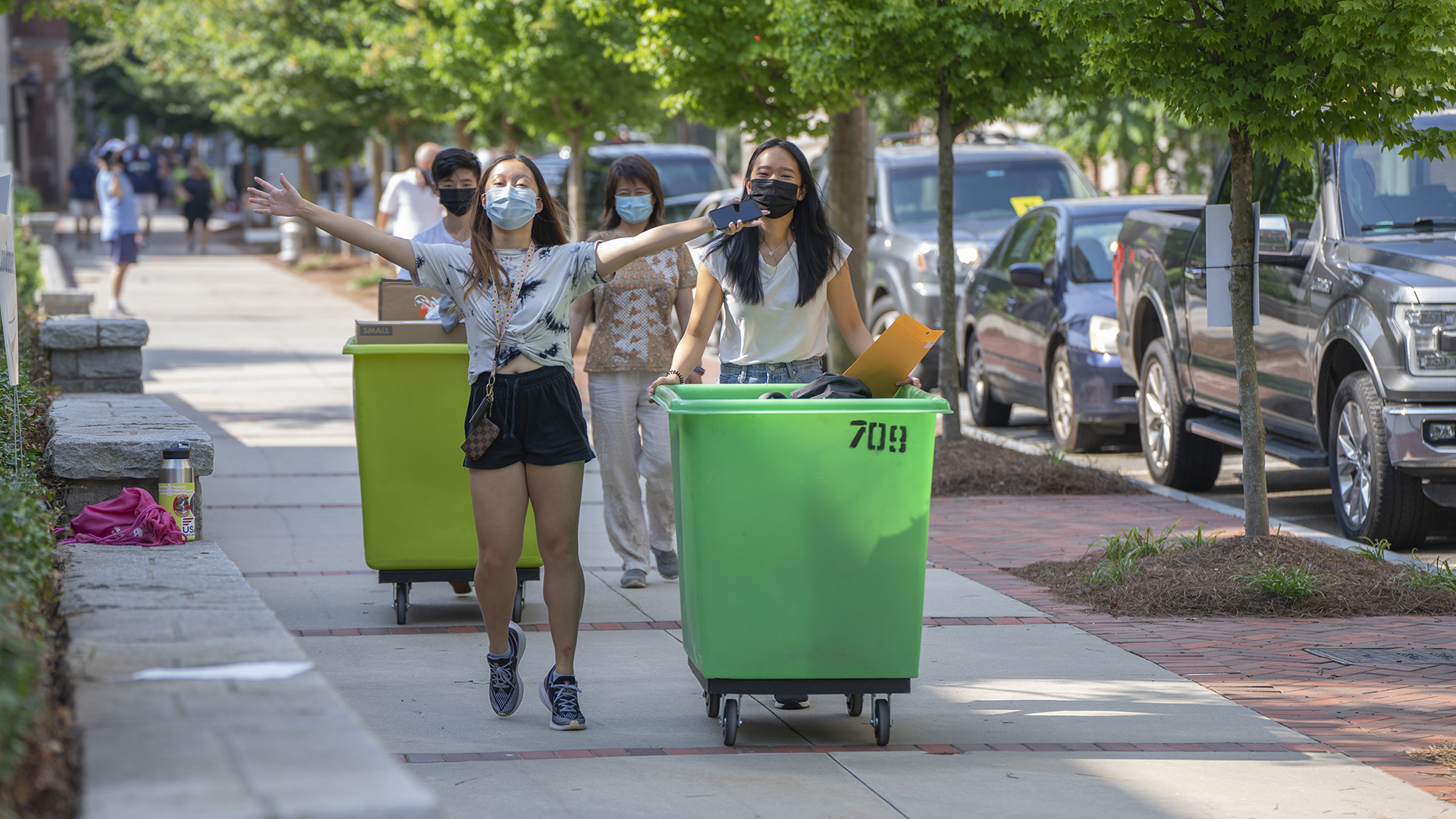 Happy students push a bin of belongings toward their on-campus home for the 2020-21 academic year during move-in weekend for first-year students. (Photo: Christopher Moore)