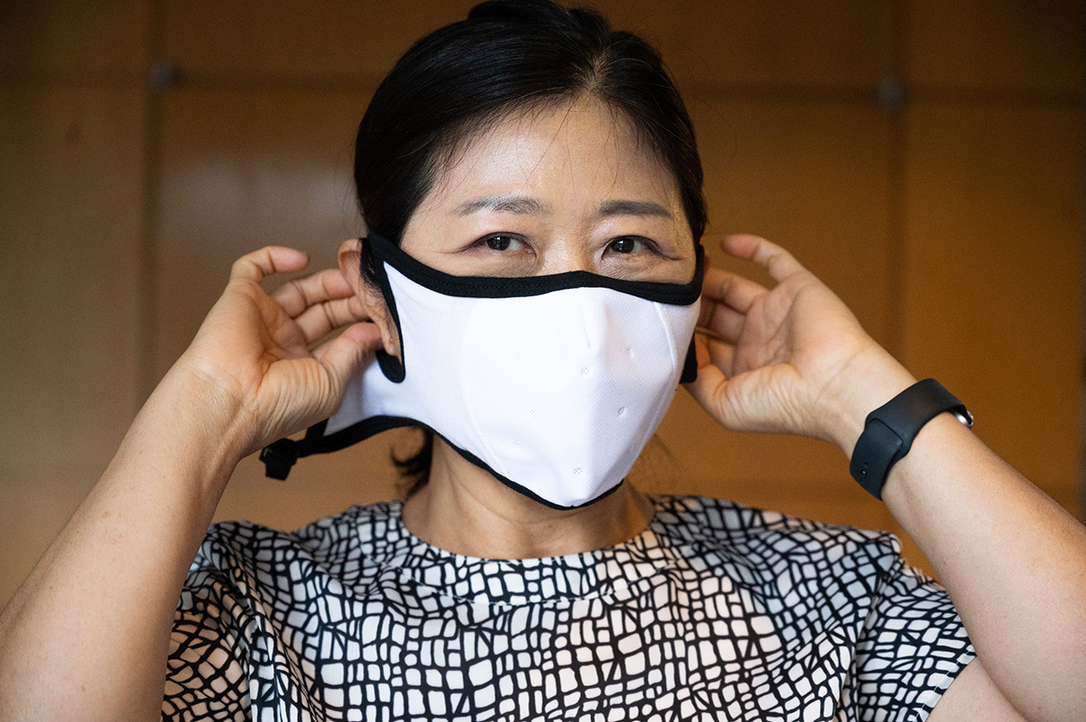 Sungmee Park puts on the mask, which was designed for better protection and comfort for the wearer. (Photo by Allison Carter)