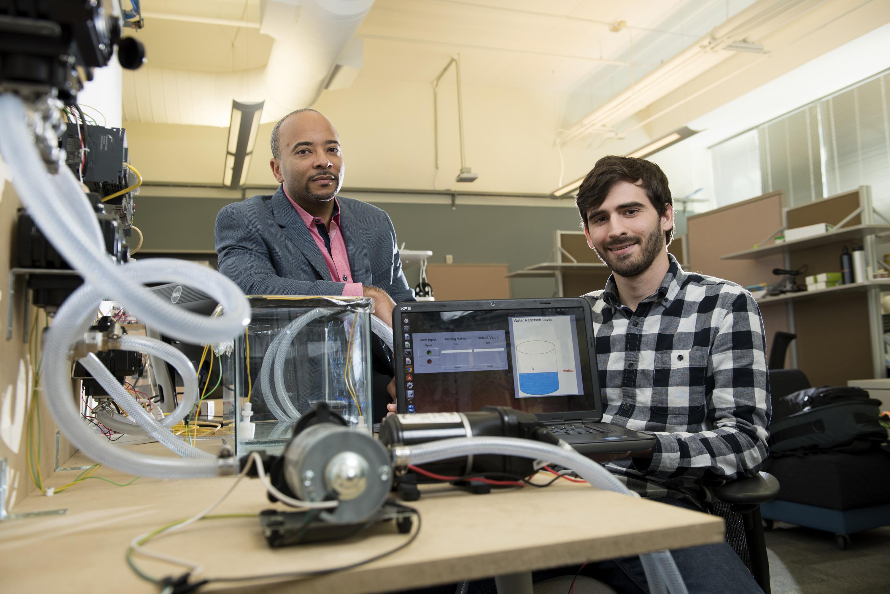 Georgia Tech researchers have developed a new form of ransomware that can take over control of a simulated water treatment plant. The simulated attack was designed to highlight vulnerabilities in the control systems used to operate industrial facilities. Shown are (left) Raheem Beyah, associate chair in the Georgia Tech School of Electrical and Computer Engineering, and David Formby, a Georgia Tech Ph.D. student. (Credit: Christopher Moore, Georgia Tech)