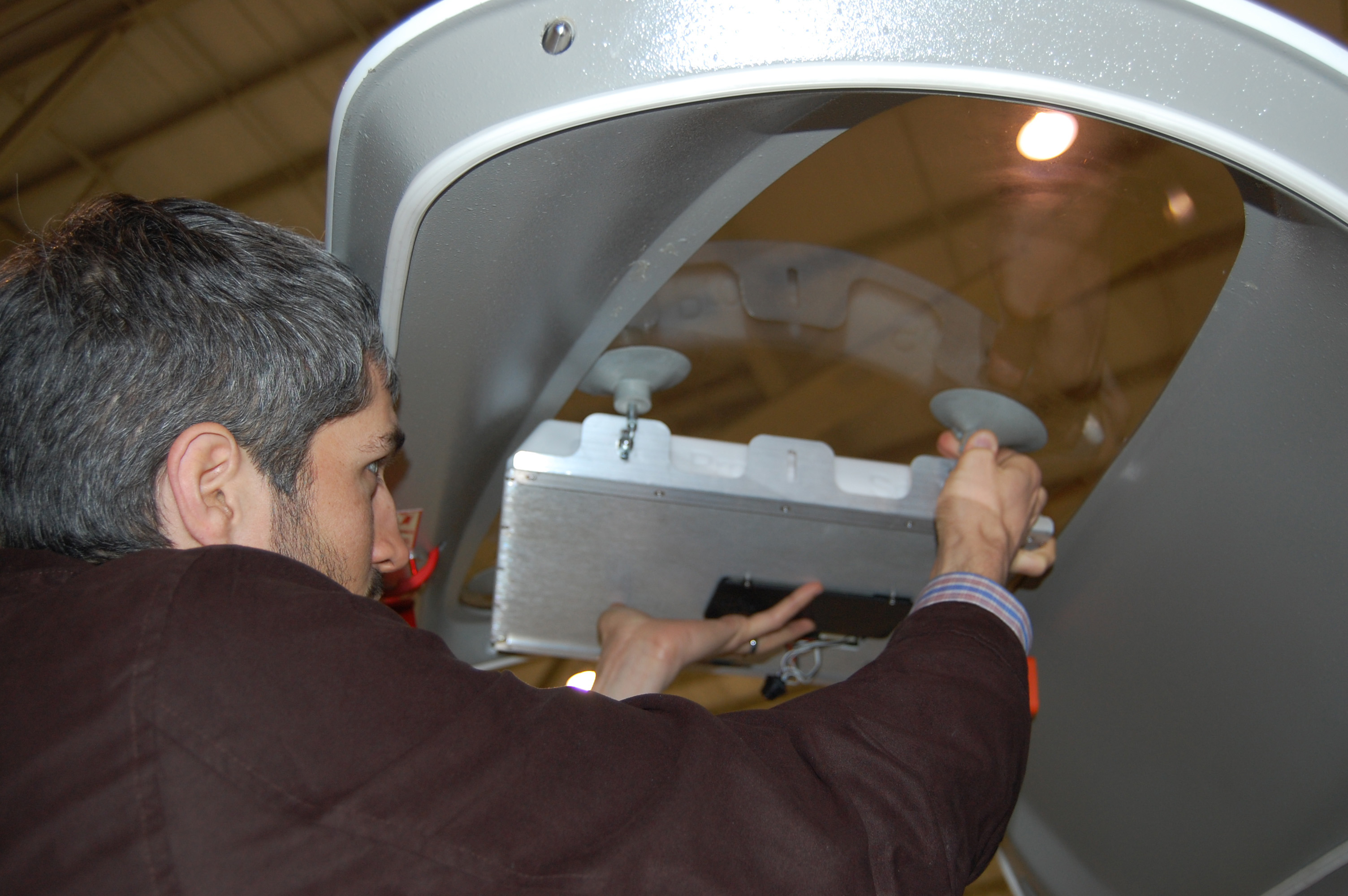 An Agile Aperture Antenna is placed in a window of an aircraft for a recent test flight. The software-defined, electronically-reconfigurable antenna can change beam directions in a thousandth of a second. Its light weight and low power requirements make it ideal for use in UAVs. (GTRI photo)