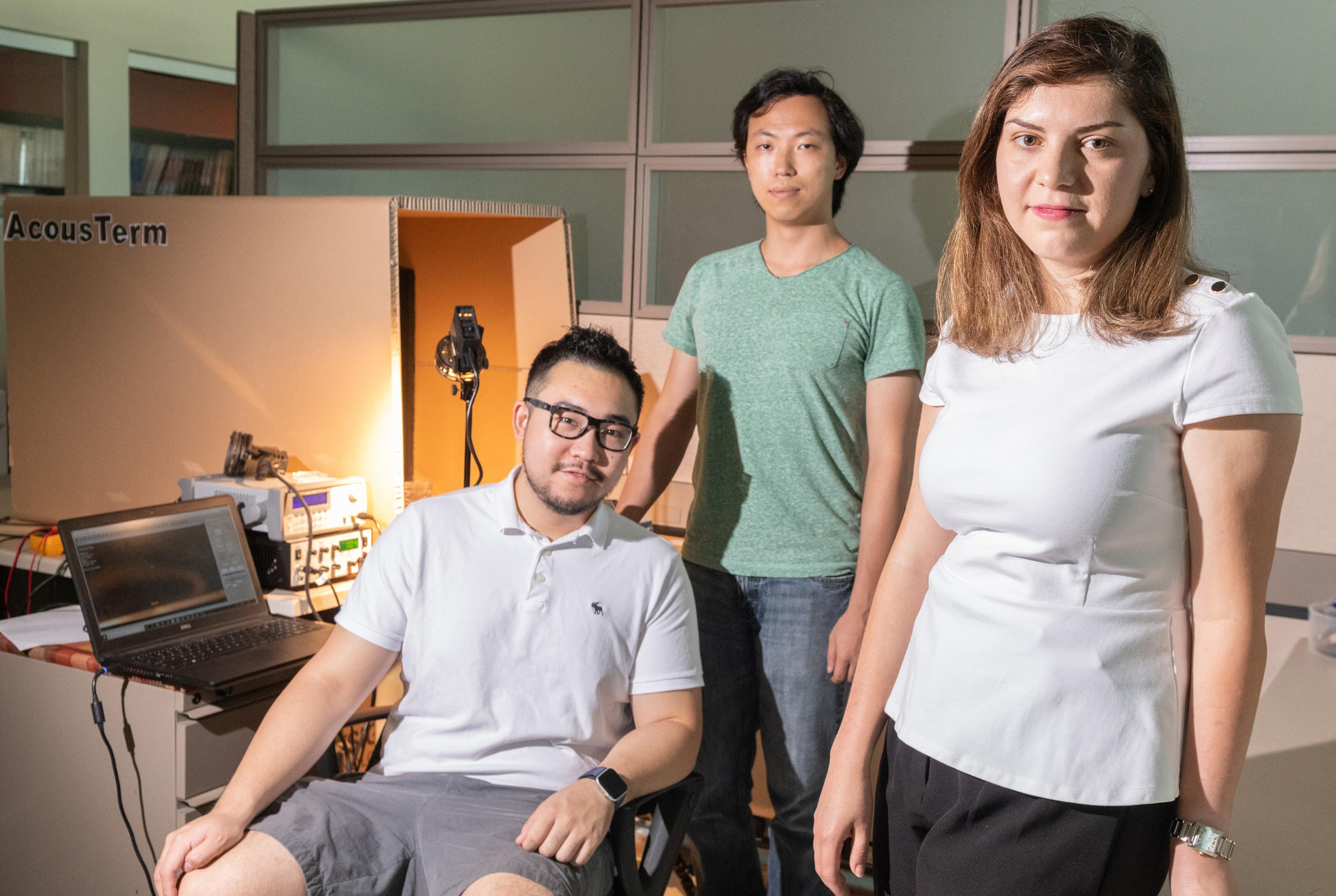 Georgia Tech researchers Azadeh Ansari, DeaGyu Kim and Zhijian (Chris) Hao are shown in their laboratory. The chamber in the background is used to test the micro-bristle-bot. (Photo: Allison Carter, Georgia Tech)