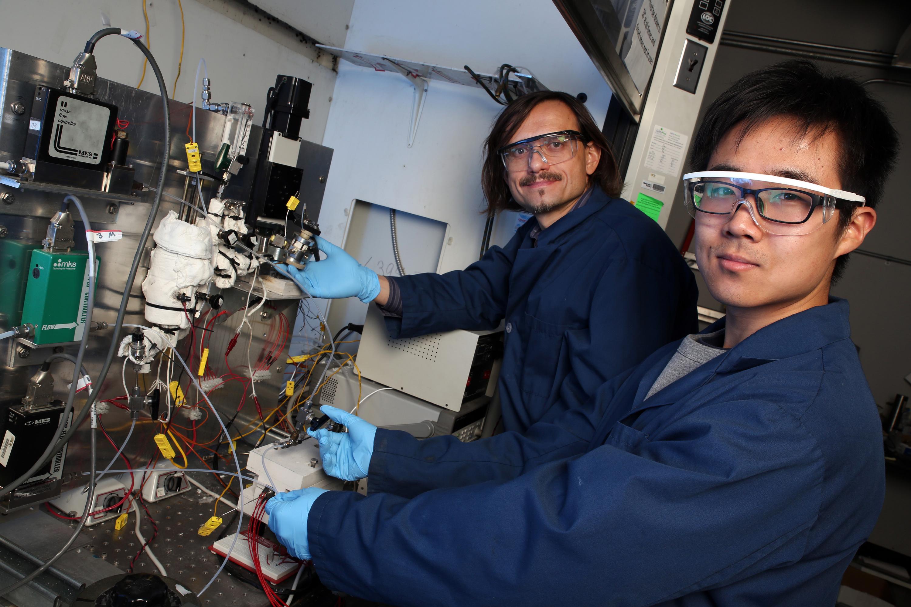 Georgia Tech professor Andrei Fedorov (left) and undergraduate research assistant Yuzhe Peng are shown with the laboratory-scale hydrogen reforming system that produces the green fuel at relatively low temperature in a process that can be scaled up or down to meet specific needs. (Credit: Candler Hobbs, Georgia Tech) Georgia Tech professor Andrei Fedorov (left) and undergraduate research assistant Yuzhe Peng are shown with the laboratory-scale hydrogen reforming system that produces the green fuel at relatively low temperature in a process that can be scaled up or down to meet specific needs. (Credit: Candler Hobbs, Georgia Tech)