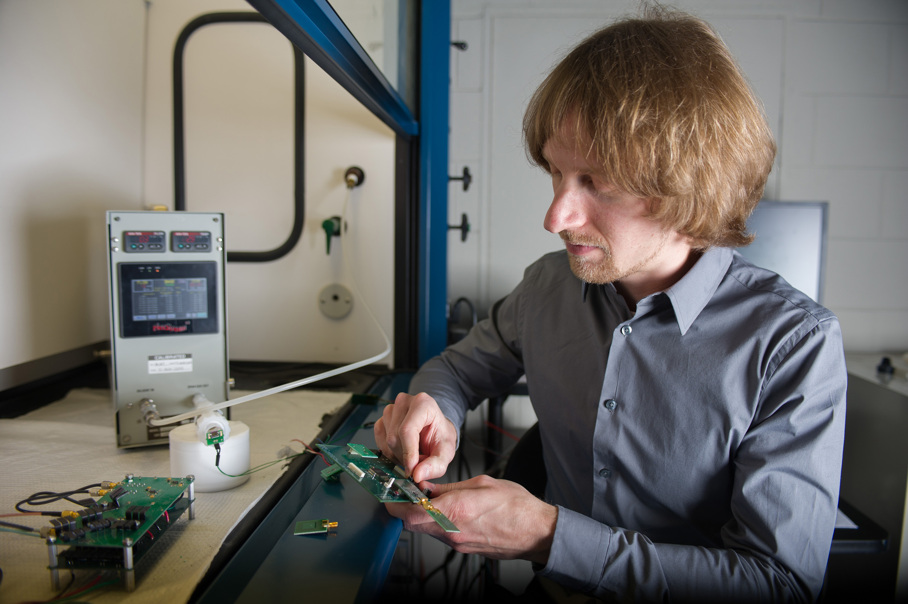 Georgia Tech Research Institute researcher Christopher Valenta inspects the RFID Enabled Sensing Testbed (R.E.S.T.), which allows rapid prototyping of RFID-enabled sensors and RF technology. (Georgia Tech Photo: Rob Felt)