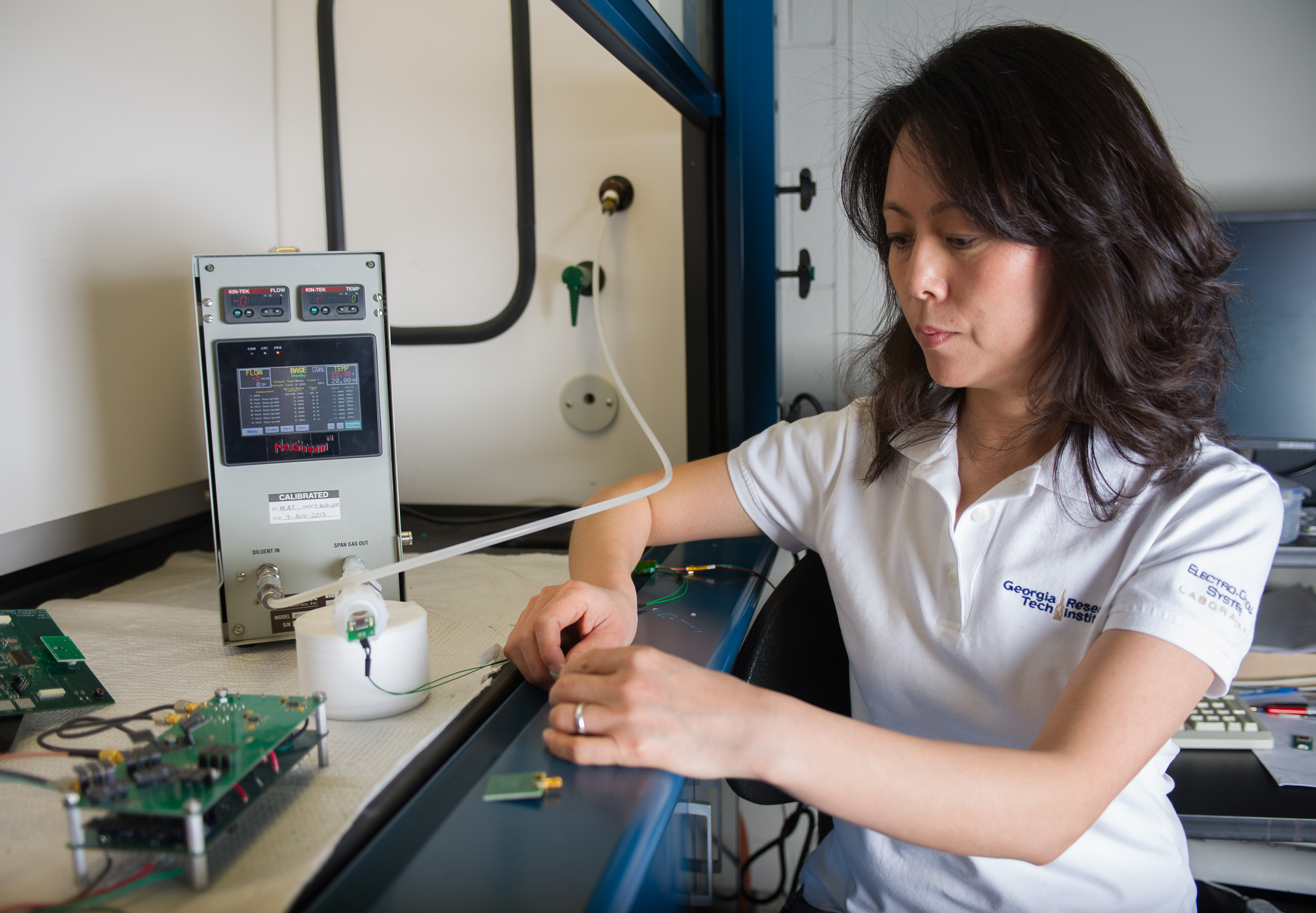 Georgia Tech Research Institute researcher Xiaojuan (Judy) Song examines a functionalized nanomaterial-based sensor used to detect chemical vapors. This sensor integrates with a 5.8 GHz RFID tag and digitally communicates information back to the reader. (Georgia Tech Photo: Rob Felt)